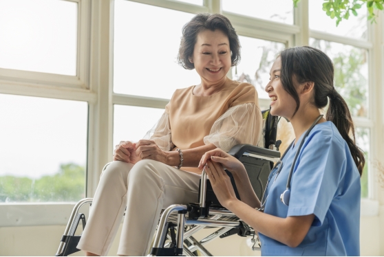asian-young-caregiver-caring-her-elderly-patient-senior-daycare-handicap-patient-wheelchair-hospital-talking-friendly-nurse-looking-cheerful-nurse-wheeling-senior-patient